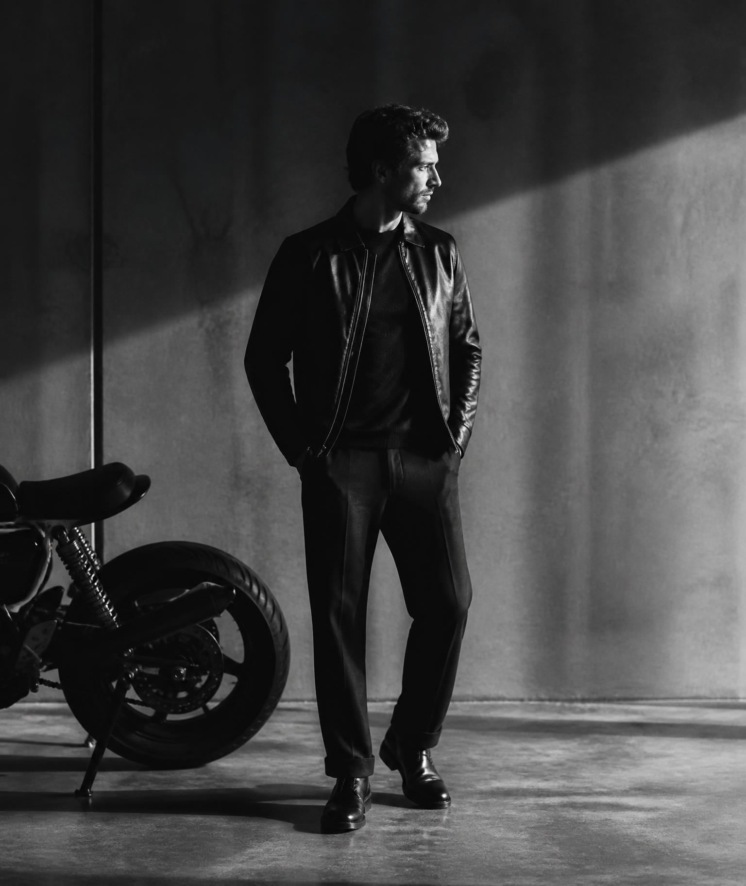 Motorbike rider in a concrete space, editorial black and white portrait